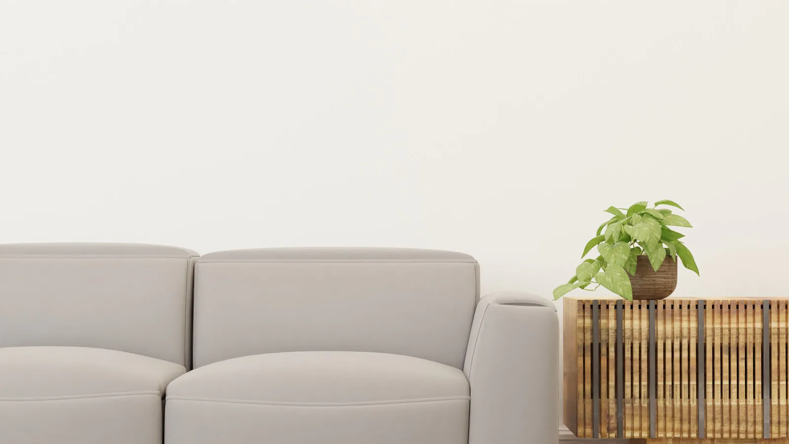 A gray sofa beside a slatted wooden table holding a single potted plant.